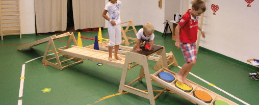 Eduygm online kaufen für Kinderbetreuung im Kübler Sport Onlineshop Kinder spielen mit einem Eduygm Bewegungsparcours aus Holz- und Polsterelementen in einer Kita