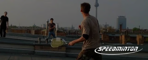 Verschiedene Spieler trainieren Speedminton mit Rackets und Speeder auf einem Vereinsfeld